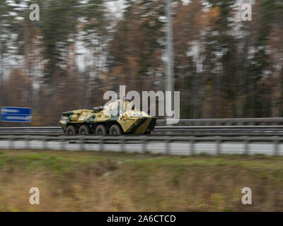 La région de Moscou, Russie, le 19 octobre 2019 : un véhicule de transport de troupes se déplace le long d'une autoroute à un terrain d'entraînement militaire. Le canon est recouvert d'une ta Banque D'Images