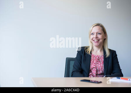 Une femme blanche est assis autour d'une table de réunion dans un bureau lumineux avec plein de fenêtres dans une combinaison intelligente Banque D'Images