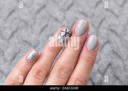 Les femmes sur chandail tricoté main gris moderne manucure close up Banque D'Images