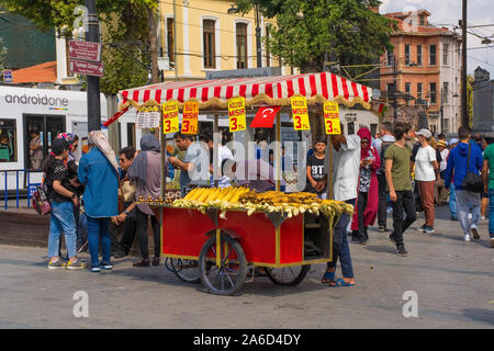 Istanbul, Turquie - 5 septembre 2019. Un vendeur de rue cuisiniers des châtaignes et des épis de maïs sur son chariot pour touristes de passage. Banque D'Images