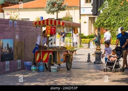 Istanbul, Turquie - 5 septembre 2019. Un vendeur de rue cuisiniers des châtaignes et des épis de maïs sur son chariot pour touristes de passage. Banque D'Images