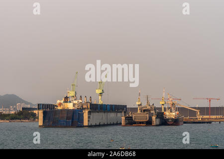 Port de Laem Chabang, Thaïlande - 17 mars 2019 : Deux cales sèches, une grande et une petite, avec à l'intérieur du navire sous Ciel de coucher du soleil. Banque D'Images