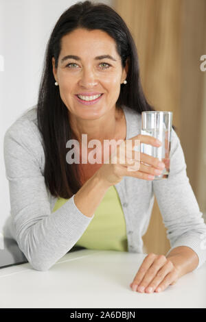 Gros plan sur verre d'eau, tenue par la main de femme Banque D'Images