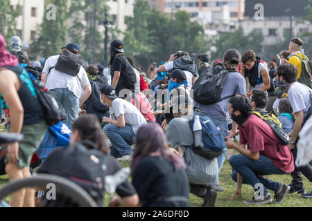 Santiago de Chile Chili 23/10/2019 Protéger les gens de coups de feu de l'armée et la police à la foule à Santiago du Chili rue Plaza de Italia Banque D'Images