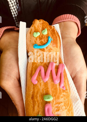 GUAGUA DE PAN - Pain garçon en langue espagnole - Gros plan sur les mains d'une femme tenant un pain sur une serviette. Banque D'Images