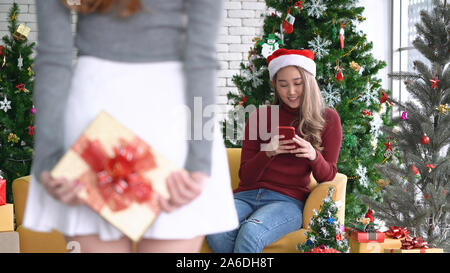 Femme Asiatique surprenant son collègue ou ami avec cadeau de Noël en vacances de Noël Banque D'Images