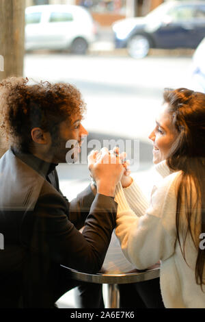 Et l'homme caucasian girl sitting at café de la rue et se tenant la main. Banque D'Images