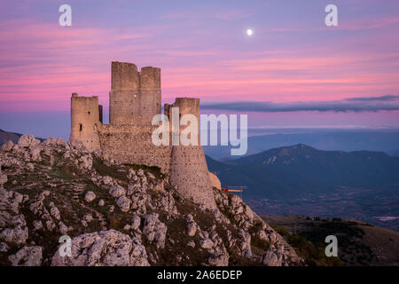 Ruines du château médiéval de Rocca Calascio après le coucher du soleil et de la lune avec l'augmentation des paysages de montagne et ciel colorés en arrière-plan, les Abruzzes, Italie Banque D'Images