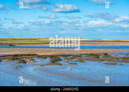 Vue sur la mudFlat à marée basse depuis le sentier national de la côte Norfolk, près de Burnham Overy Staithe, de l'île Scolt Head à l'arrière, East Anglia, Angleterre, Royaume-Uni. Banque D'Images