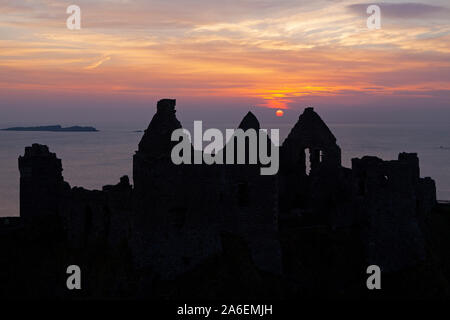 Coucher de soleil au château de Dunluce dans le comté d'Antrim, en Irlande du Nord. Banque D'Images