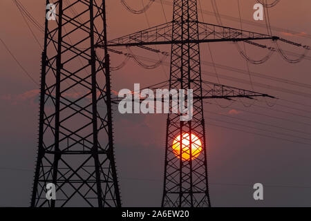Pylônes en face du soleil couchant Banque D'Images
