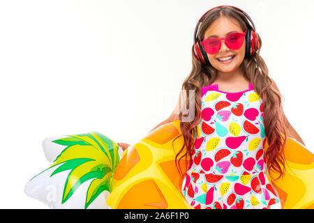 Fille avec de longs cheveux et des lunettes en crucifié maillot se trouve dans un anneau de caoutchouc et de sourires Banque D'Images