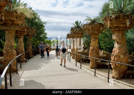 Les touristes marchant dans un chemin au parc Guell à Barcelone, Espagne Banque D'Images