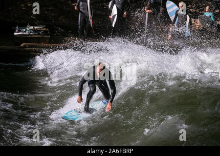 Un internaute chevauche la vague artificielle à Eisbachwelle, Munich, Allemagne. Partie d'une rivière, le spot est utilisée pour une compétition de surf annuelle. Banque D'Images