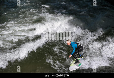 Un internaute chevauche la vague artificielle à Eisbachwelle, Munich, Allemagne. Partie d'une rivière, le spot est utilisée pour une compétition de surf annuelle. Banque D'Images