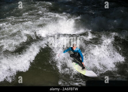 Un internaute chevauche la vague artificielle à Eisbachwelle, Munich, Allemagne. Partie d'une rivière, le spot est utilisée pour une compétition de surf annuelle. Banque D'Images