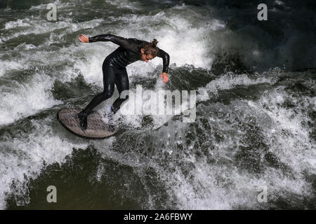 Un internaute chevauche la vague artificielle à Eisbachwelle, Munich, Allemagne. Partie d'une rivière, le spot est utilisée pour une compétition de surf annuelle. Banque D'Images