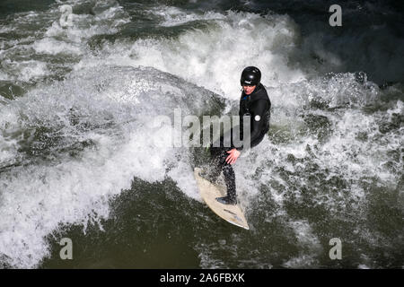 Un internaute chevauche la vague artificielle à Eisbachwelle, Munich, Allemagne. Partie d'une rivière, le spot est utilisée pour une compétition de surf annuelle. Banque D'Images