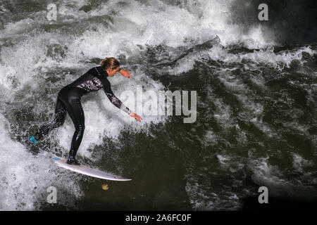 Un internaute chevauche la vague artificielle à Eisbachwelle, Munich, Allemagne. Partie d'une rivière, le spot est utilisée pour une compétition de surf annuelle. Banque D'Images