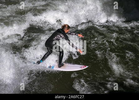 Un internaute chevauche la vague artificielle à Eisbachwelle, Munich, Allemagne. Partie d'une rivière, le spot est utilisée pour une compétition de surf annuelle. Banque D'Images