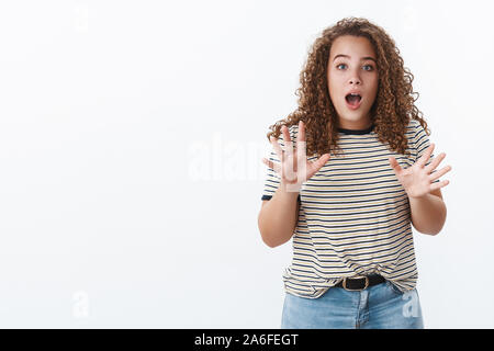 Girl racontant de nouvelles palpitantes de dire que vous ne croyez pas. Impressionné excité copine chubby attrayant aux cheveux bouclés gesturing soulevées palms Banque D'Images