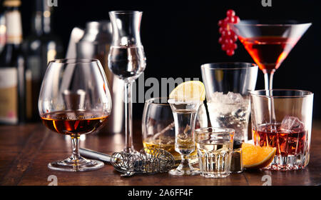 Grand choix de boissons alcoolisées et de cocktails servis dans des verres debout sur un comptoir de bar en bois Banque D'Images