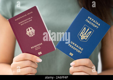 Femme tenant deux passeports. Ukrainiens et allemands Banque D'Images