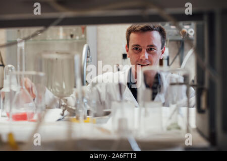 Homme scientifique effectue des expériences chimiques avec des liquides dans la science lab Banque D'Images