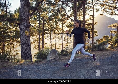 Young woman jogging dans les bois le matin, Afrique du Sud Banque D'Images