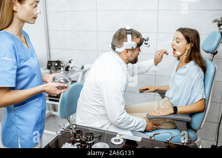 Avec des patients pour l'ORL oto-rhino-laryngologiste et sous-bureau au cours de l'examen médical, le médecin examinant la gorge Banque D'Images