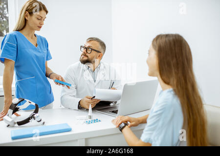 Jeune patient à un rendez-vous avec l'oto-rhino-laryngologistes, séance au cours de la consultation dans le lumineux ENT office interior Banque D'Images