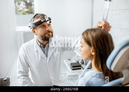 L'examen oto-rhino-laryngologiste hauts épis avec diapason ORL pour un jeune patient dans le bureau médical. Test de l'audition à lames vibrantes concept Banque D'Images