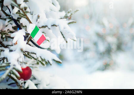 Noël en Italie. Arbre de Noël couvert de neige, des décorations et un drapeau de l'Italie. Contexte La forêt enneigée en hiver. Carte de vœux de Noël. Banque D'Images