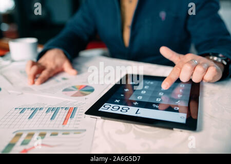 Close-up de l'homme d'affaires l'analyse de la main de Bill sur tablette numérique plus de 24 Banque D'Images
