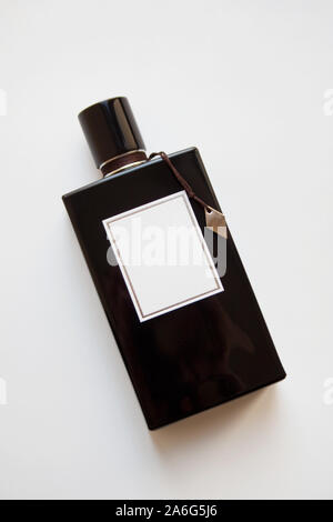 Flacon de parfum en verre noir isolé sur fond blanc Banque D'Images