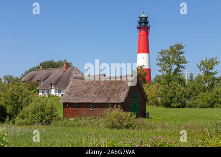 Maisons d'Adobe et le phare sur l'île de Pellworm en Frise du Nord, Schleswig-Holstein, Allemagne. Banque D'Images