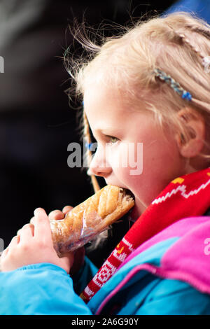 Une jolie petite fille bénéficie d'une saucisse chaude à un match de football de Stoke City FC, BET 365 Stadium Banque D'Images