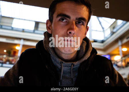 Un jeune homme attend, à Stoke on Trent gare routière pour son autobus, transports publics, patience Banque D'Images