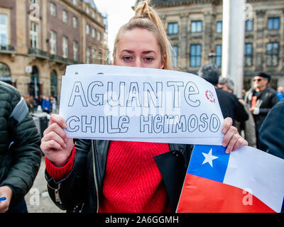 Une femme tenant une pancarte en face de son visage pendant la manifestation.La communauté chilienne vivant aux Pays-Bas continue la démonstration pour montrer leur mécontentement face à la situation actuelle au Chili et d'exiger la démission de Sebastián Piñera, président du Chili depuis 2018. Les gens portaient des vêtements noirs en faveur des victimes lors des manifestations au Chili. Banque D'Images