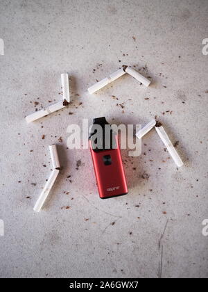 Vape cigarette électronique de l'appareil aspire breeze, comme alternative aux fumeurs de Marlboro cigarettes or brisé et dispersé sur le tabac texturé Blanc ba Banque D'Images