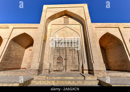 Façade de l'ancien caravansérail Ahmadjon, 19e siècle, avec porte en bois sculpté à Boukhara, Ouzbékistan. Banque D'Images