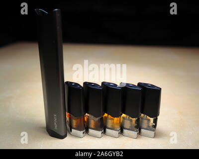 Smok Infinix pod rechargeables vape pen cigarette électronique avec pods rempli d'e-Jus de différentes nuances d'orange disposés dans un gradient, isoler Banque D'Images