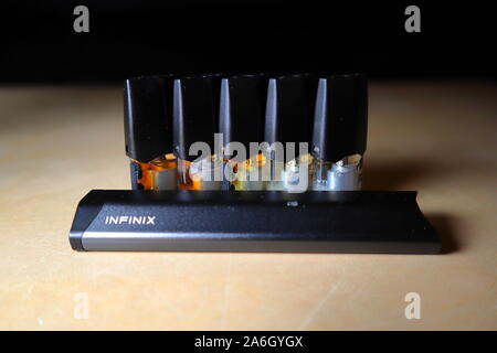 Smok Infinix pod rechargeables vape pen cigarette électronique avec pods rempli d'e-Jus de différentes nuances d'orange disposés dans un gradient, isoler Banque D'Images