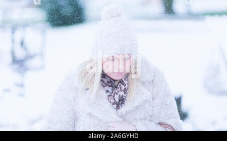 Une belle femme marchant dans un sentier forestier à la veille de Noël, jour avec la neige tombant autour d'elle, à pied, Trentham Gardens Banque D'Images