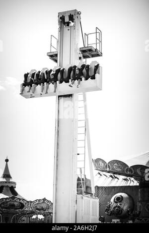 Un groupe de visiteurs de profiter des promenades sur les montagnes russes, dodgems et d'autres manèges et attractions pleasureland au plaisir, des terres dans le pays de Galles Banque D'Images