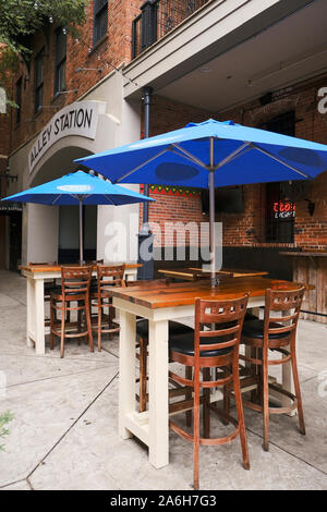 Deux hightop vides des tables avec parasols à la terrasse extérieure d'un restaurant local à Montgomery, en Alabama, USA. Banque D'Images
