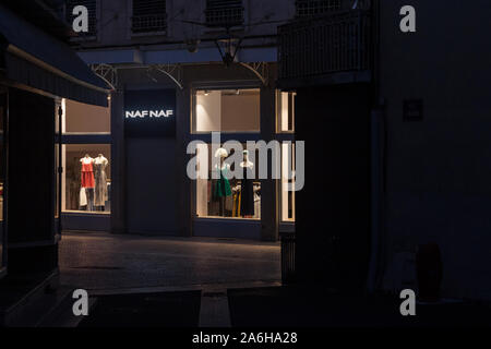 BOURGOIN-JALLIEU, FRANCE - 16 juillet 2019 : Naf Naf Logo en face de leur boutique dans une rue piétonne déserte la nuit. Partie de Vivarte, Naf Naf est un Banque D'Images