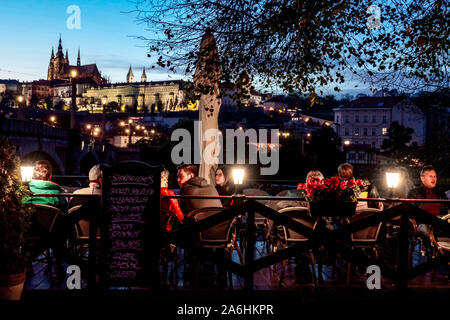 Prague gens dans un bar au bord de la rivière Vltava, Restaurant, touristes surplombant le château de Prague nuit Château de Prague vue ambiance du soir Banque D'Images