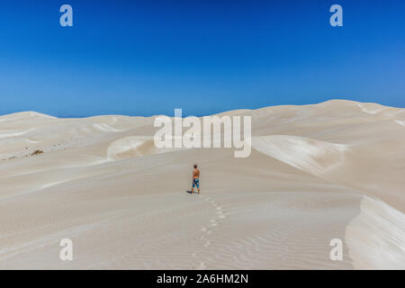 Jeune homme marche sur les dunes de sable sans fin et large, Nullabor Dessert, Australie Banque D'Images