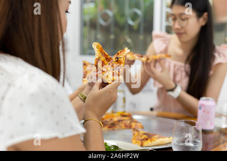 Les femmes avec les meilleurs amis avoir pizza dans un restaurant. Banque D'Images
